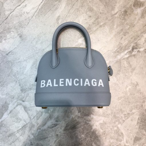 BALENCIAGA Mini Ville Logo Leather Bag. Original Quality Bag. Authentic Epi leather. Metal Toned Hardware. BALENCIAGA Sales Box and Dust Bag. Authenticity Card. BALENCIAGA's Ville mini bowling bag is crafted of grained calfskin printed with a large statement logo at the front and back. This design works as a zipped-top construction with a padlock charm to ensure your valuables are securely stowed. The versatile style can be carried by its rolled handles or over the shoulder via a detachable flat strap. | CRIS&COCO Authentic Quality Designer Bags and Luxury Accessories