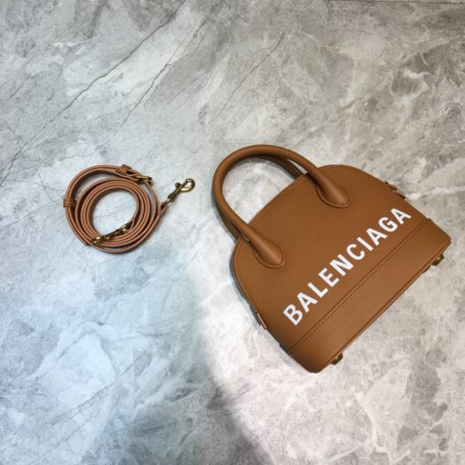 BALENCIAGA Mini Ville Logo Leather Bag. Original Quality Bag. Authentic Epi leather. Metal Toned Hardware. BALENCIAGA Sales Box and Dust Bag. Authenticity Card. BALENCIAGA's Ville mini bowling bag is crafted of grained calfskin printed with a large statement logo at the front and back. This design works as a zipped-top construction with a padlock charm to ensure your valuables are securely stowed. The versatile style can be carried by its rolled handles or over the shoulder via a detachable flat strap. | CRIS&COCO Authentic Quality Designer Bags and Luxury Accessories