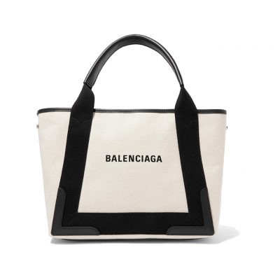 BALENCIAGA 'Cabas' Canvas and Leather Tote. Authentic Quality Bag with literature, dust bag, box and authenticity card. This Cabas tote has been made from Ecru canvas that's solely decorated with the iconic brand's updated logo lettering. Trimmed with smooth black leather at the edges and handles, it's fitted with snap fastenings at each side to create extra room on the days you need to carry your tablet or a notebook. | CRIS&COCO Authentic Quality bags and Accessories