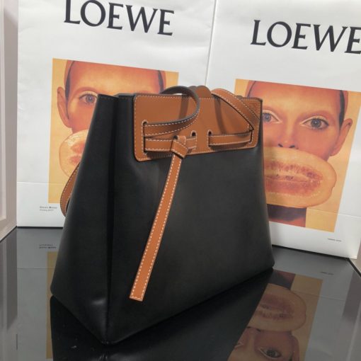 LOEWE Lazo Top Handle Bag. Authentic Quality Bag with literature, gift box, dust bag and authenticity card. A highly chic and sophisticated bag, the Lazo features the recognizable emblematic Gate knot. Contrasting calfskin straps holds the bag, cinching to fasten the bag effortlessly. Creating a sinuous accordion soft silhouette with soft natural calfskin, this novel interpretation is the next must-have chic functional bag of the season. The soft and slouchy calfskin bag is devoid of any zips for the closure and instead relies on the contrasting calfskin straps to cinch and fasten the opening. A relaxed update on a classic bag design. | CRIS&COCO Authentic Quality Designer Bags and Luxury Accessories