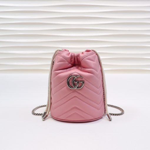 GUCCI GG Marmont Mini Bucket Bag. Original Quality Bag including gift box, literature, dust bag, authenticity card. The world of GG Marmont expands with the introduction of a mini bucket bag shape crafted from Matelassé leather in vibrant tones. Inspired by an archival design from the '70s, a hallmark era of the House, the Double G decorates the front of this accessory. Featuring a chain strap and drawstring closure the versatile shape can be worn as shoulder and as a crossbody bag. | Cris and Coco. High Quality Bags and Luxury Accessories