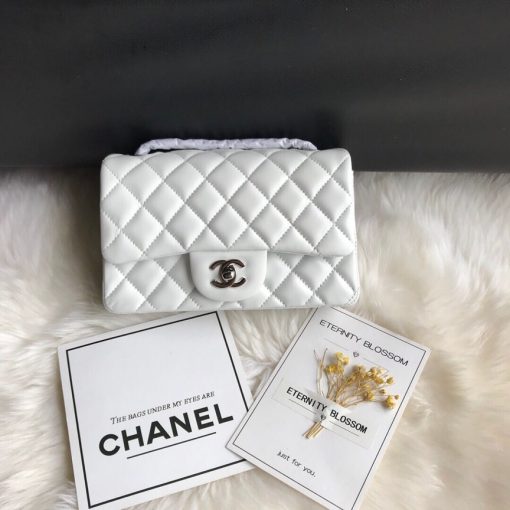 CHANEL Classic New Mini 20 cm Flap Bag. Original Quality Bag including gift box, care book, dust bag, authenticity card. This chic petite shoulder bag is crafted of luxurious shimmery lambskin leather. The crossbody bag features a long chain-link leather threaded shoulder strap and front flap with a CC turn lock. The flap opens to an interior of matching leather with zipper and patch pockets. Enjoy this fabulous bag for everyday essentials or special events with this timeless classic. | CRIS AND COCO High Quality Bags and Luxury Accessories