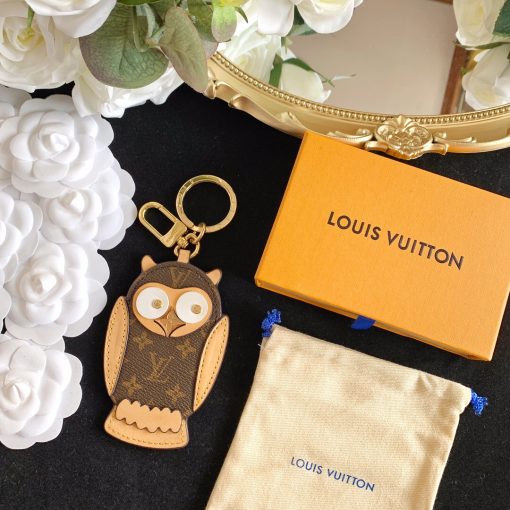 LOUIS VUITTON Owl Bag-Charm & Key Holder. Original Quality Charm including gift box, care book, dust bag, authenticity card. The mascot on the Owl bag charm and key holder is brought to life with LV studs for eyes and a Monogram Flower beak. Gold-color hardware joins calf leather and Monogram Eclipse canvas in a playful mingling of the House's signature materials. The hook and ring on this are both engraved with the Louis Vuitton signature for an elegant finish. | CRIS&COCO Authentic Quality Designer Bags and Luxury Accessories