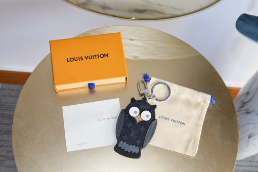 LOUIS VUITTON Owl Bag-Charm & Key Holder. Original Quality Charm including gift box, care book, dust bag, authenticity card. The mascot on the Owl bag charm and key holder is brought to life with LV studs for eyes and a Monogram Flower beak. Gold-color hardware joins calf leather and Monogram Eclipse canvas in a playful mingling of the House's signature materials. The hook and ring on this are both engraved with the Louis Vuitton signature for an elegant finish. | CRIS&COCO Authentic Quality Designer Bags and Luxury Accessories