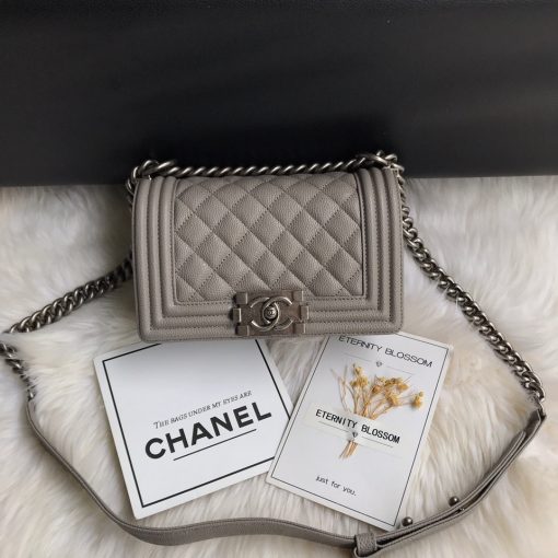 CHANEL Small Boy Handbag. Original Quality Bag including gift box, care book, dust bag, authenticity card. Even though the Boy was only introduced in 2011, the style has quickly achieved the status of an icon. Designed by Karl Lagerfeld and named after Boy Capel, the now legendary love of Coco Chanel’s life, the bag encapsulates masculine chic conveyed through rigid structure, boxy shape and sharp corners. This CHANEL Small Handbag is instantly recognizable for its simple, boxy silhouette and sharp corners, embellished only with a contrasting, bold-looking link chain strap which is the main feature of the bag. This most popular variations of the Chanel Boy are available in either caviar or lambskin. There are no external pockets and the sole adornment is the quilted fascia. | CRIS&COCO Authentic Quality Designer Bags and Luxury Accessories