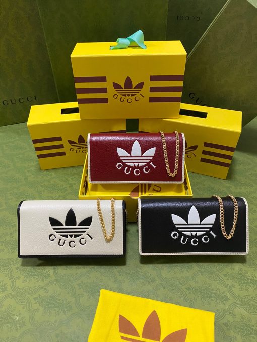 GUCCI X ADIDAS Wallet With Chain.  Original Quality Wallet including gift box, care book, dust bag, authenticity card. Part of the GUCCI X ADIDAS collection, this chain wallet features the Gucci Trefoil print. Emblematic House’s motifs mix with those of the historic sportswear brand adidas. The collection sees both heritages encoded in a trio of lines, where adidas and Gucci combine archival emblems. Creative Director, Alessandro Michele pulls inspiration from his memories of the ‘80s and ‘90s for a collection that is both nostalgia-driven and contemporary. | CRIS&COCO Authentic Quality Designer Bag and Luxury Accessories