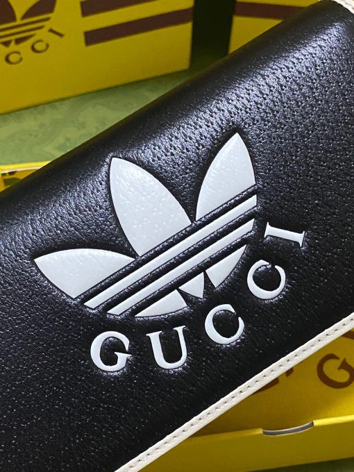 GUCCI X ADIDAS Wallet With Chain.  Original Quality Wallet including gift box, care book, dust bag, authenticity card. Part of the GUCCI X ADIDAS collection, this chain wallet features the Gucci Trefoil print. Emblematic House’s motifs mix with those of the historic sportswear brand adidas. The collection sees both heritages encoded in a trio of lines, where adidas and Gucci combine archival emblems. Creative Director, Alessandro Michele pulls inspiration from his memories of the ‘80s and ‘90s for a collection that is both nostalgia-driven and contemporary. | CRIS&COCO Authentic Quality Designer Bag and Luxury Accessories