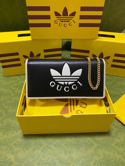 GUCCI X ADIDAS Wallet With Chain.  Original Quality Wallet including gift box, care book, dust bag, authenticity card. Part of the GUCCI X ADIDAS collection, this chain wallet features the Gucci Trefoil print. Emblematic House’s motifs mix with those of the historic sportswear brand adidas. The collection sees both heritages encoded in a trio of lines, where adidas and Gucci combine archival emblems. Creative Director, Alessandro Michele pulls inspiration from his memories of the ‘80s and ‘90s for a collection that is both nostalgia-driven and contemporary. | CRIS&COCO Authentic Quality Designer Bag and Luxury Accessories