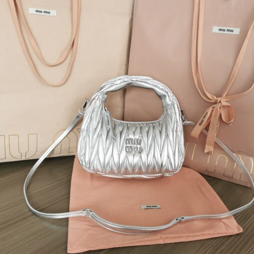 MIU MIU Wander Matelassé Mini Hobo Bag. Original Quality Bag including gift box, care book, dust bag, authenticity card. The Miu Wander bag is reinterpreted season after season, becoming an iconic accessory of Miu Miu collections. Made of matelassé nappa leather, the bag is characterized by the sophisticated, three-dimensional effect created by the refined workmanship. The hobo shape, blending retro inspirations and contemporary elegance, becomes a new synonym of modern femininity. | CRIS&COCO Authentic Quality Designer Bag and Luxury Accessories