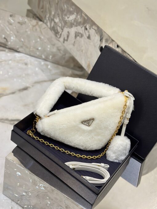 PRADA Shearling Mini Bag. Original Quality Bag including gift box, care book, dust bag, authenticity card. The softness and fuzziness of shearling accentuate the modern, wintry allure of this mini-bag characterized by its harmonious and delicate shape. The bag accented with a chain handle is decorated with the enameled metal triangle logo. | CRIS&COCO Authentic Quality Designer Bags and Luxury Accessories