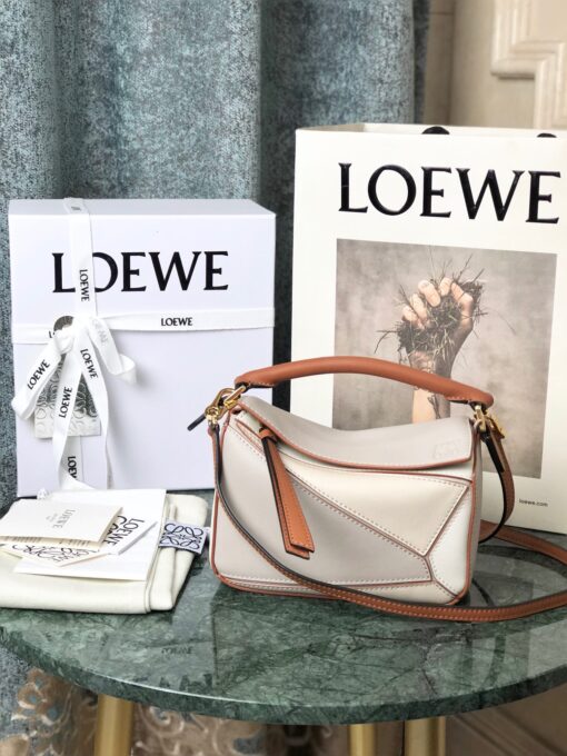 LOEWE Mini Puzzle Bag. Original Quality Bag including gift box, care book, dust bag, authenticity card. The Puzzle bag is the debut bag for LOEWE by Creative Director Jonathan Anderson. A cuboid shape and precise cutting technique create Puzzle’s distinctive geometric lines. This mini version is crafted in contrasting calfskins. | CRIS AND COCO Authentic Quality Luxury Accessories