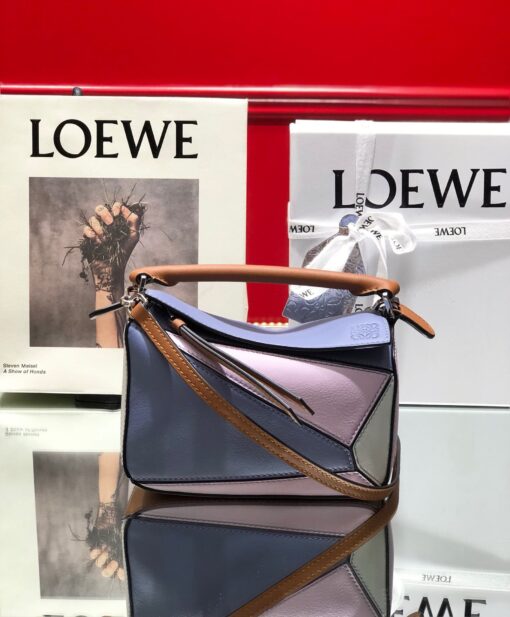 LOEWE Mini Puzzle Bag. Original Quality Bag including gift box, care book, dust bag, authenticity card. The Puzzle bag is the debut bag for LOEWE by Creative Director Jonathan Anderson. A cuboid shape and precise cutting technique create Puzzle’s distinctive geometric lines. This mini version is crafted in contrasting calfskins. | CRIS AND COCO Authentic Quality Luxury Accessories