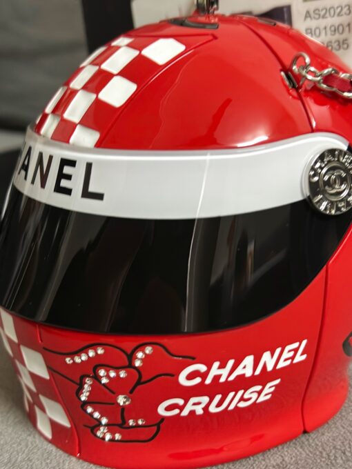 CHANEL Helmet Minaudiere. High-End Quality Bag including gift box, care book, dust bag, authenticity card. This precious creation was unveiled along with the Slot Machine Minaudière and Sphere Minaudière at #CHANELCruise 2023. The 11 cm by 10 cm objet d’art sees diamanté crystals and Chanel logos peppering the full resin exterior for maximum effect. Capturing attention in eye-catching black, red and white, it is equal parts clutch and eye candy. | CRIS AND COCO Authentic Quality Luxury Accessories