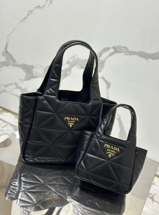 PRADA Nappa Tote Bag. High-End Quality Bag including gift box, care book, dust bag, authenticity card. An unusual triangle motif creates three-dimensional plays on this nappa-leather shopper bag, reinterpreting the iconic Prada shape. Defined by a versatile allure, the style is completed by a magnetic clasp and signature enameled-metal triangle logo. | CRIS AND COCO Authentic Quality Luxury Accessories