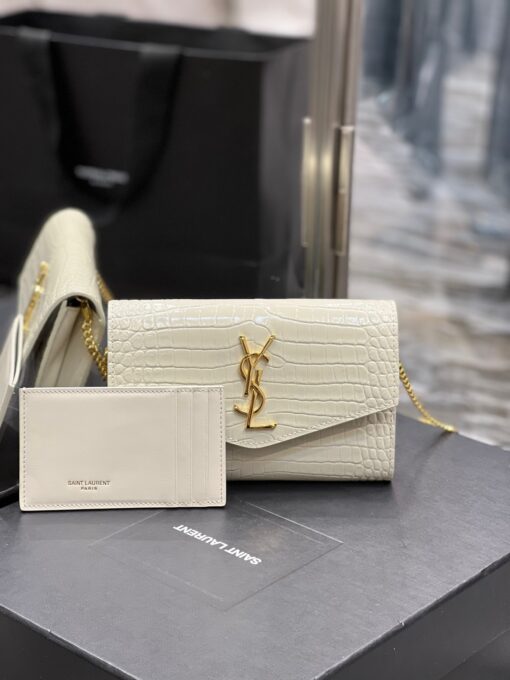 SAINT LAURENT Uptown Chain Wallet. High-End Quality Bag including gift box, care book, dust bag, authenticity card. Mini envelope bag decorated with the cassandre, featuring a removable chain strap for shoulder or hand carry as a clutch. A fragments card case with three card slots is included. | CRIS AND COCO Authentic Quality Luxury Accessories