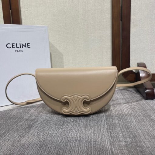 CELINE Besace Cuir Triomphe. High-End Quality Bag including gift box, care book, dust bag, authenticity card. Offered in the half-moon shape that’s all the rage now, the significantly wider format measures 23 cm from tip to tip. Each bag opens via a snap button closure to reveal a roomy interior compartment and a flat inner pocket. Another noticeable feature of the bag lies in the oversized Triomphe logo. With tonal stitching along the edges, the logo on the Triomphe Canvas comes in contrasting Tan leather. For a monochrome effect, go for the Ice Blue and Tan with logos in matching colours. | CRIS AND COCO Authentic Quality Luxury Accessories