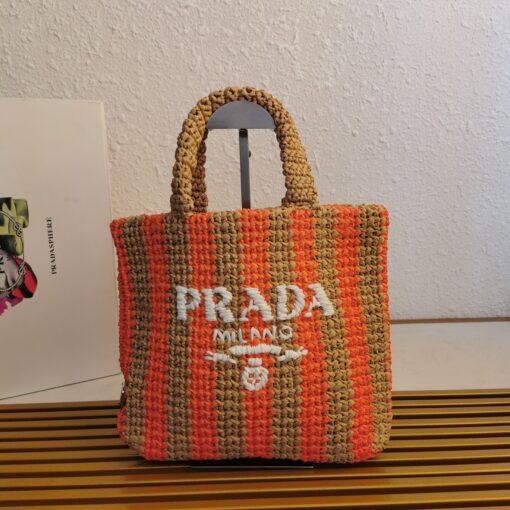 PRADA Small Crochet Tote Bag. Elevate Your Look with an Exquisite Tote Bag! This exquisite tote bag has a deconstructed design made of a light, natural material with a summery mood, raffia-effect yarn. Embroidered lettering logo decorates the front, and the emblematic triangle in enameled metal is the perfect finishing touch to the side. | CRIS&COCO Authentic Quality Designer Bags and Luxury Accessories