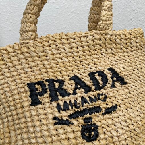 PRADA Small Crochet Tote Bag. Elevate Your Look with an Exquisite Tote Bag! This exquisite tote bag has a deconstructed design made of a light, natural material with a summery mood, raffia-effect yarn. Embroidered lettering logo decorates the front, and the emblematic triangle in enameled metal is the perfect finishing touch to the side. | CRIS&COCO Authentic Quality Designer Bags and Luxury Accessories