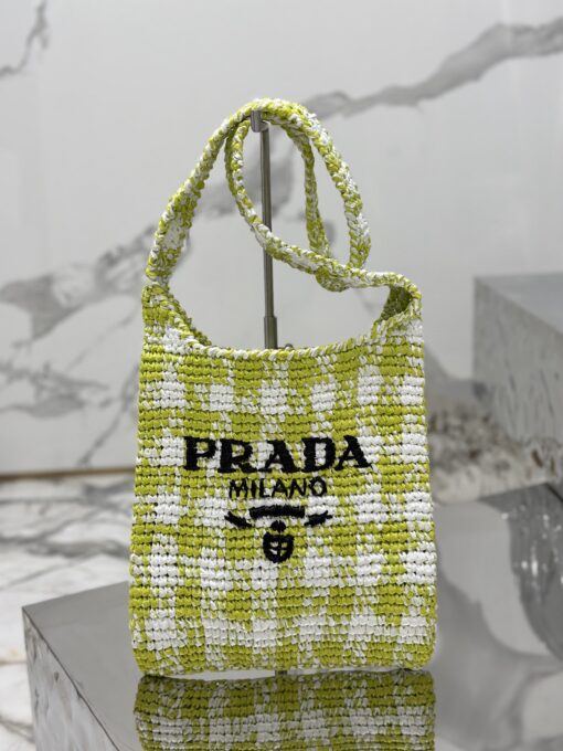 PRADA Crochet Bag- where refined logos meet natural raffia-inspired beauty.  Introducing a beautifully crafted tote bag, featuring a gentle, deconstructed design, elegantly crafted from raffia-effect yarn. This lightweight and natural material exudes a delightful summery vibe. The front adorns a sleek enameled metal triangle logo and delicately embroidered lettering logo, engaging in a captivating and harmonious aesthetic conversation. | CRIS&COCO Authentic Quality Designer Bags and Luxury Accessories