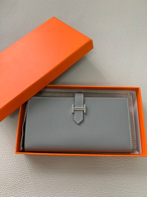 HERMÈS Béarn Wallet: Where Elegance Meets Functionality, Inspired by the Heart of France's South-West. The Béarn pays homage to the enchanting South-West region of France and stands as a distinguished member of a collection that honors various distinctive French regions. This wallet or card holder boasts an elegantly sleek design and is thoughtfully equipped with multiple compartments tailored for organizing credit cards, coins, and bills with ease. Upon closure, a supple leather flap gracefully glides into an iconic "H" shaped clasp, elevating it to a timeless classic. It presents a generous array of leather types and colors, allowing one to harmonize effortlessly with the latest trends in style. | CRIS&COCO Authentic Quality Designer Bags and Luxury Accessories