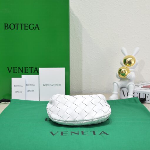 BOTTEGA VENETA Mini Jodie. Mini Marvel: Elevate Your Essentials. Introducing the BV Mini Jodie by Daniel Lee, a captivating embodiment of the mini bag trend infused with a captivating minimalist essence. True to the distinctive allure of the Jodie collection, this rendition showcases the iconic Intrecciato weave and the signature knot embellishment. Delicately compact, it effortlessly nestles under your arm akin to a charming baguette bag, yet offers ample space for your essentials such as your phone, cards, and keys. Despite its diminutive size, this mini bag radiates a vibrant aura through an array of lively hues, ensuring it leaves a memorable impression. | CRIS&COCO Authentic Quality Designer Bags and Luxury Accessories