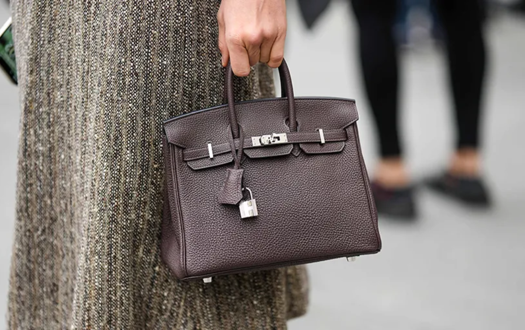 A close-up of the renowned Hermès Birkin bag, emphasizing its distinctive silhouette, luxurious leather texture, and the signature lock and strap design.