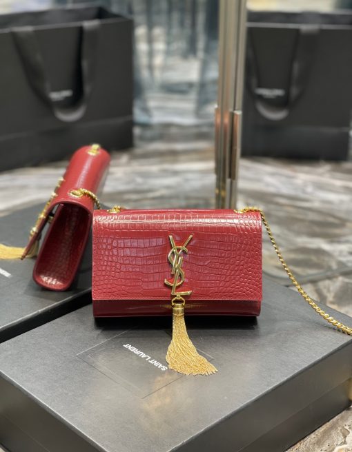 SAINT LAURENT Small 'Kate' Bag with Tassel. Original Quality Bag including gift box, care book, dust bag, authenticity card. Monogram Saint Laurent bag adorned with a curb chain, interlocking YSL initials in metal, and a metallic tassel. Crafted from leather, this Kate shoulder bag from Saint Laurent is decorated with a signature YSL monogram plaque and a hanging tassel detail to the front for an extra refined touch. The perfect go-to for a night out. Featuring a chain shoulder strap, a foldover top with magnetic closure, a main internal compartment, an internal slip pocket, an internal logo patch, an internal logo stamp, and metal hardware.