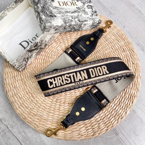 DIOR Christian Dior Shoulder Strap. Original Quality Strap including gift box, care book, dust bag, authenticity card. The 'Christian Dior' signature is featured at the center of the slender shape, framed by black calfskin on either side. Two antique gold-finish metal snap hooks attach the strap to the bag of choice. The strap may be worn over the shoulder or crossbody for a highly personalized style.