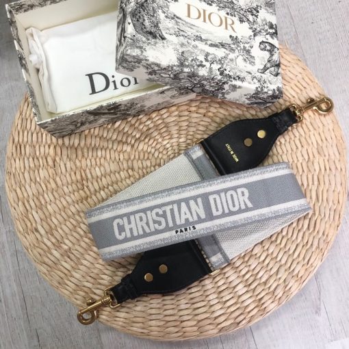 DIOR Christian Dior Shoulder Strap. Original Quality Strap including gift box, care book, dust bag, authenticity card. The 'Christian Dior' signature is featured at the center of the slender shape, framed by black calfskin on either side. Two antique gold-finish metal snap hooks attach the strap to the bag of choice. The strap may be worn over the shoulder or crossbody for a highly personalized style.