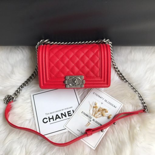 CHANEL Small Boy Handbag. Original Quality Bag including gift box, care book, dust bag, authenticity card. Even though the Boy was only introduced in 2011, the style has quickly achieved the status of an icon. Designed by Karl Lagerfeld and named after Boy Capel, the now legendary love of Coco Chanel’s life, the bag encapsulates masculine chic conveyed through rigid structure, boxy shape and sharp corners. This CHANEL Small Handbag is instantly recognizable for its simple, boxy silhouette and sharp corners, embellished only with a contrasting, bold-looking link chain strap which is the main feature of the bag. This most popular variations of the Chanel Boy are available in either caviar or lambskin. There are no external pockets and the sole adornment is the quilted fascia.