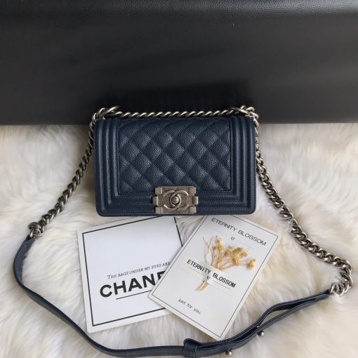 CHANEL Small Boy Handbag. Original Quality Bag including gift box, care book, dust bag, authenticity card. Even though the Boy was only introduced in 2011, the style has quickly achieved the status of an icon. Designed by Karl Lagerfeld and named after Boy Capel, the now legendary love of Coco Chanel’s life, the bag encapsulates masculine chic conveyed through rigid structure, boxy shape and sharp corners. This CHANEL Small Handbag is instantly recognizable for its simple, boxy silhouette and sharp corners, embellished only with a contrasting, bold-looking link chain strap which is the main feature of the bag. This most popular variations of the Chanel Boy are available in either caviar or lambskin. There are no external pockets and the sole adornment is the quilted fascia.