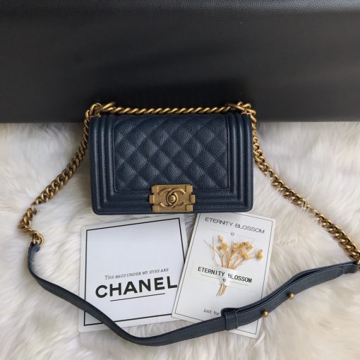 CHANEL Small Boy Handbag. Original Quality Bag including gift box, care book, dust bag, authenticity card. Even though the Boy was only introduced in 2011, the style has quickly achieved the status of an icon. Designed by Karl Lagerfeld and named after Boy Capel, the now legendary love of Coco Chanel’s life, the bag encapsulates masculine chic conveyed through rigid structure, boxy shape and sharp corners. This CHANEL Small Handbag is instantly recognizable for its simple, boxy silhouette and sharp corners, embellished only with a contrasting, bold-looking link chain strap which is the main feature of the bag. This most popular variations of the Chanel Boy are available in either caviar or lambskin. There are no external pockets and the sole adornment is the quilted fascia.