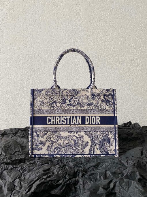 DIOR Book Tote. Original Quality Bag including gift box, care book, dust bag, authenticity card. This Book Tote is an original style introduced by Creative Director Maria Grazia Chiuri. This has become a staple of the Dior aesthetic. Ideally designed to carry all your daily essentials, the small shape is fully embroidered and the 'Christian Dior' signature on the front. This carryall is a perfect example of the Dior savoir-faire and also may be coordinated with a pouch or other small leather goods for a complete look.