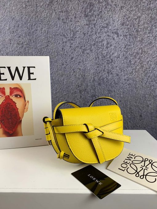 LOEWE Gate Mini Grained-Leather Cross-Body Bag. Original Quality Bag. Authentic Style. Genuine Calf Leather. Metal Hardware. Authentic Packaging. Original Quality Dust Bag. Loewe brings signature finesse to the micro-mini bag trend with this tiny red iteration of its coveted Gate style. The bag takes inspiration from countryside gate latch fastenings to create this grained-leather Gate cross-body bag. It's crafted to a half-moon shape with a long shoulder strap that is finished with black lacquered edges, then opens to reveal a suede interior with a single slip pocket.