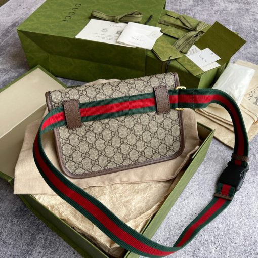 GUCCI Neo Vintage GG Supreme belt bag. The belt bag in GG Supreme has a retro-influenced design. Trimmed with leather, the style is meant to be worn around the waist, securing with a Web strap and buckle closure. Beige/ebony GG Supreme canvas, a material with low environmental impact, with brown leather trims. Green and red Web. Oval Gucci leather tag with a feline head. Adjustable nylon Web belt with plastic buckle closure.