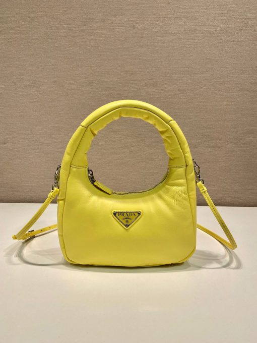 PRADA Soft Padded Mini Bag. Original Quality Bag including gift box, care book, dust bag, authenticity card. A harmonious, bold silhouette characterizes this mini-bag made of padded leather accented with the detachable, adjustable shoulder strap. Defined by its versatile allure, the accessory has a zipper closure and is decorated with the emblematic enameled metal triangle logo.