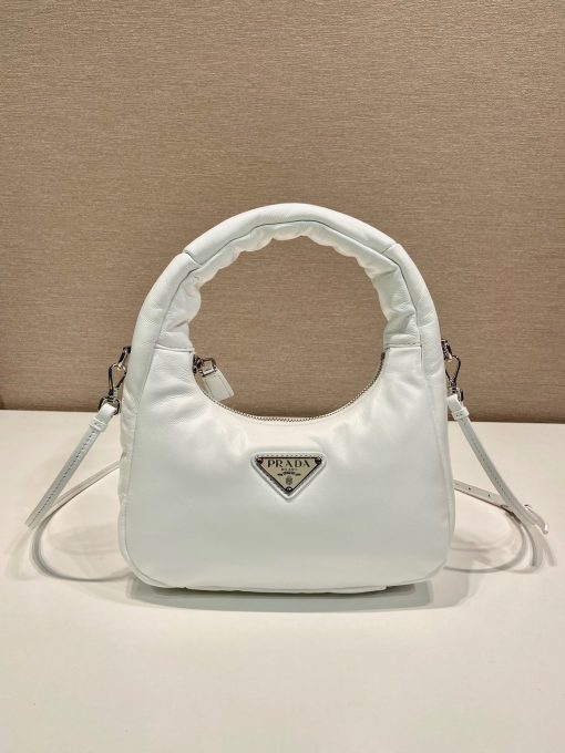 PRADA Soft Padded Mini Bag. Original Quality Bag including gift box, care book, dust bag, authenticity card. A harmonious, bold silhouette characterizes this mini-bag made of padded leather accented with the detachable, adjustable shoulder strap. Defined by its versatile allure, the accessory has a zipper closure and is decorated with the emblematic enameled metal triangle logo.