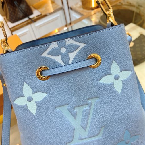 LOUIS VUITTON NéoNoé BB. Made from two-color Monogram Empreinte leather, the gradient pastel colorway of the Monogram Giant motif brings a festival feel to this resolutely on-trend NéoNoé BB bucket bag. It features a detachable top handle for hand and elbow carry as well as an adjustable strap for hand carry and over-the-shoulder wear.