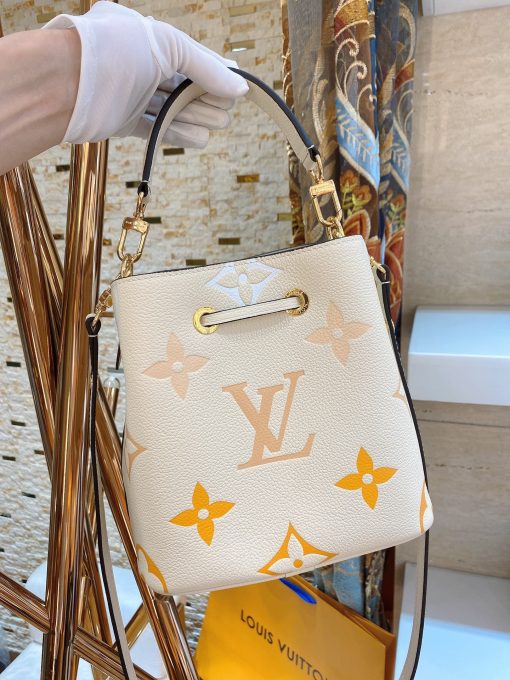 LOUIS VUITTON NéoNoé BB. Made from two-color Monogram Empreinte leather, the gradient pastel colorway of the Monogram Giant motif brings a festival feel to this resolutely on-trend NéoNoé BB bucket bag. It features a detachable top handle for hand and elbow carry as well as an adjustable strap for hand carry and over-the-shoulder wear.