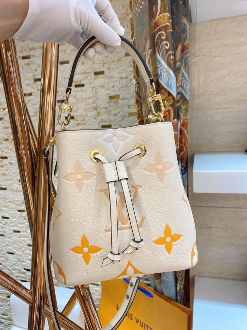 LOUIS VUITTON NéoNoé BB. Made from two-color Monogram Empreinte leather, the gradient pastel colorway of the Monogram Giant motif brings a festival feel to this resolutely on-trend NéoNoé BB bucket bag. It features a detachable top handle for hand and elbow carry as well as an adjustable strap for hand carry and over-the-shoulder wear.