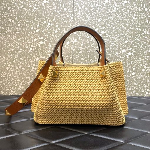 VALENTINO GARAVANI Straw Summer Small Tote.  Original Quality Bag including gift box, literature, dust bag, authenticity card. The Summer tote bag is defined by its woven raffia design and the brass-toned VLogo plaque, the unmistakable symbol of Valentino Garavani. The detachable shoulder strap is adorned with the iconic Roman Studs, another of the brand's signature details.