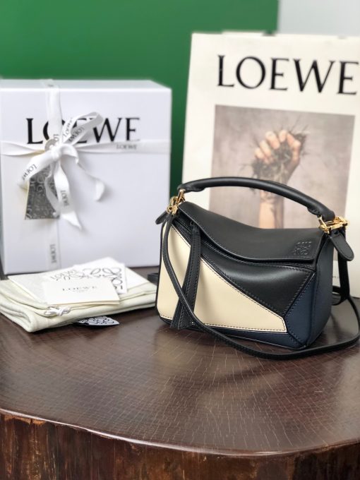 LOEWE Mini Puzzle Bag. Original Quality Bag including gift box, care book, dust bag, authenticity card. The Puzzle bag is the debut bag for LOEWE by Creative Director Jonathan Anderson. A cuboid shape and precise cutting technique create Puzzle’s distinctive geometric lines. This mini version is crafted in contrasting calfskins.