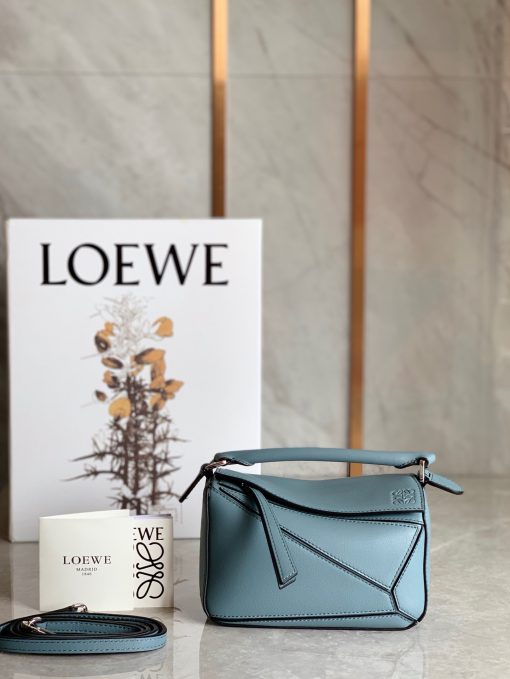 LOEWE Mini Puzzle Bag. Original Quality Bag including gift box, care book, dust bag, authenticity card. The Puzzle bag is the debut bag for LOEWE by Creative Director Jonathan Anderson. A cuboid shape and precise cutting technique create Puzzle’s distinctive geometric lines. This mini version is crafted in contrasting calfskins.