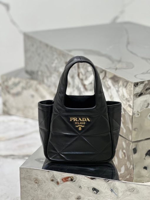 PRADA Nappa Tote Bag. High-End Quality Bag including gift box, care book, dust bag, authenticity card. An unusual triangle motif creates three-dimensional plays on this nappa-leather shopper bag, reinterpreting the iconic Prada shape. Defined by a versatile allure, the style is completed by a magnetic clasp and signature enameled-metal triangle logo.