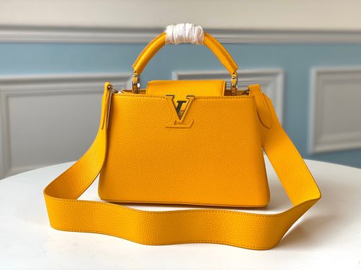 LOUIS VUITTON Capucines Mini. Original Quality Bag including gift box, literature, dust bag, authenticity card. Fashioned from vibrantly colored Taurillon leather, the Capucines Mini handbag pops. The fresh new colorway is perfectly complemented by the discreet metal handle rings. Like all Capucines, the Mini can be carried with the flap out for simple sophistication or tucked inside to feature the LV Initials.