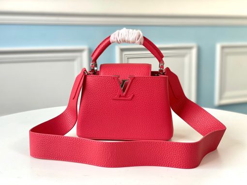 LOUIS VUITTON Capucines Mini. Original Quality Bag including gift box, literature, dust bag, authenticity card. Fashioned from vibrantly colored Taurillon leather, the Capucines Mini handbag pops. The fresh new colorway is perfectly complemented by the discreet metal handle rings. Like all Capucines, the Mini can be carried with the flap out for simple sophistication or tucked inside to feature the LV Initials.