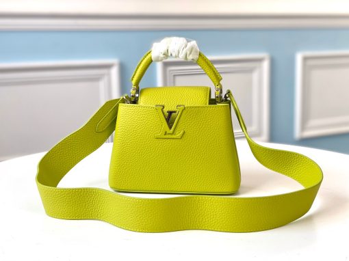 LOUIS VUITTON Capucines Mini. Original Quality Bag including gift box, literature, dust bag, authenticity card. Fashioned from vibrantly colored Taurillon leather, the Capucines Mini handbag pops. The fresh new colorway is perfectly complemented by the discreet metal handle rings. Like all Capucines, the Mini can be carried with the flap out for simple sophistication or tucked inside to feature the LV Initials.