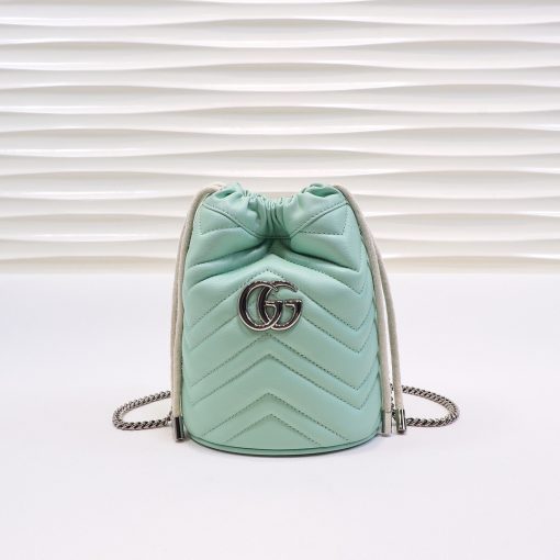 GUCCI GG Marmont Mini Bucket Bag. Original Quality Bag including gift box, literature, dust bag, authenticity card. The world of GG Marmont expands with the introduction of a mini bucket bag shape crafted from Matelassé leather in vibrant tones. Inspired by an archival design from the '70s, a hallmark era of the House, the Double G decorates the front of this accessory. Featuring a chain strap and drawstring closure the versatile shape can be worn as shoulder and as a crossbody bag.