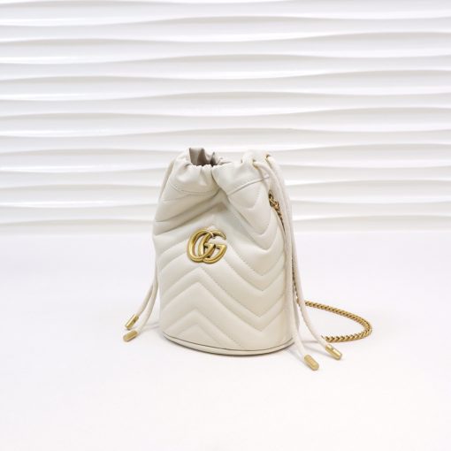 GUCCI GG Marmont Mini Bucket Bag. Original Quality Bag including gift box, literature, dust bag, authenticity card. The world of GG Marmont expands with the introduction of a mini bucket bag shape crafted from Matelassé leather in vibrant tones. Inspired by an archival design from the '70s, a hallmark era of the House, the Double G decorates the front of this accessory. Featuring a chain strap and drawstring closure the versatile shape can be worn as shoulder and as a crossbody bag.