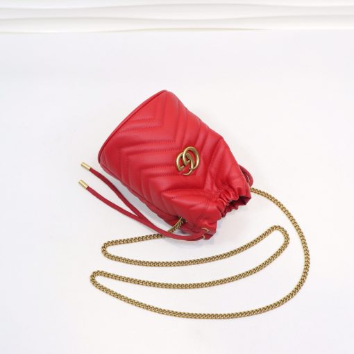 GUCCI GG Marmont Mini Bucket Bag. Original Quality Bag including gift box, literature, dust bag, authenticity card. The world of GG Marmont expands with the introduction of a mini bucket bag shape crafted from Matelassé leather in vibrant tones. Inspired by an archival design from the '70s, a hallmark era of the House, the Double G decorates the front of this accessory. Featuring a chain strap and drawstring closure the versatile shape can be worn as shoulder and as a crossbody bag.